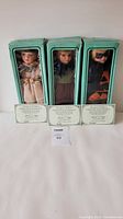 Three boxed porcelain dolls in original teal colored boxes labeled 'Sweetheart Limited Edition Collection' with certificates of authenticity displayed in front.