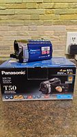 Front view of Panasonic SDR-T50 camcorder on top of original box showing branding and model details.