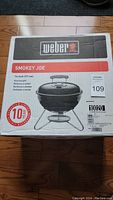 Full box view showing Weber brand and Smokey Joe model name with 14 inch size and charcoal grill type.