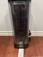 Front view of the humidifier showing the tall transparent water tank and attached power cord.