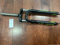 Full view of black Epic Hiland front suspension fork for 29" wheel with straight steerer tube on wood floor.