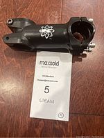 Top angle photo of black Steam bike stem showing logo and clamp bolts.