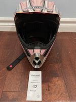 Front view of kids full face helmet showing AMC logo on top and chin strap with red button on the left side.