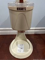 Full side view of the cream-colored Hershey's branded ice cream maker showing design and base.