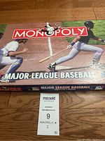 Monopoly Major League Baseball themed board game box showing baseball players and logos.