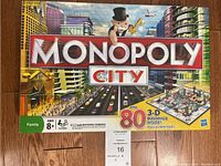 Top view of Monopoly City box with cityscape artwork, Mr. Monopoly mascot, and text about 80 3D buildings.