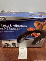 Box of the Homedics Shiatsu & Vibration Neck Massager showing product image, key features like heat and rotating massage mechanism, and some usage information.
