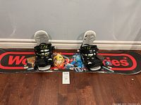 Front view of the winter snowboard displaying cartoon graphics and bindings.