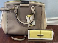 Front view of the River Island structured handbag showing beige, white and yellow color blocks with metal logo plaque and handles.