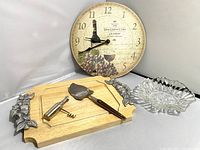 All items in lot arranged showing grape-themed board, clock, glass dish, cheese slicer and corkscrew