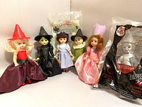 Seven Madame Alexander Wizard of Oz mini dolls lined up showing all figures and outfits