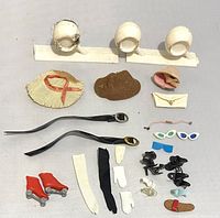 Top-down photo showing all vintage Barbie accessories and doll items arranged neatly including hats, belts, gloves, shoes, glasses, and small jewelry.