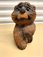 Front view of carved wood bear showing detailed facial features and textured fur.
