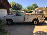 Full side profile of white Chevrolet C30 with utility bed and ladder rack