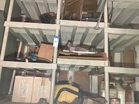 Shelf overview showing yellow fuel tank, red electric chain saw housing, propeller blades and tackle boxes