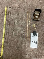 Multiple chains, unicorn pendant, and ring arranged on carpet with measuring tape