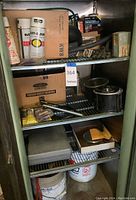 Photo of metal cabinet shelves with Rust-Oleum spray cans, Loctite adhesives, and various small hardware items.
