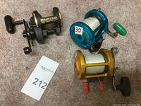 Three reels on carpet, black/gold, blue, gold