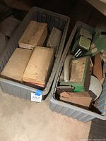 Two large plastic bins containing various tools, original boxes for timers, and other hardware.