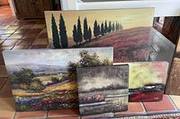 Four reproduction landscape canvases of various sizes arranged on tiled floor showing distinct natural scenes