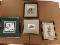 Top view of all four framed pictures arranged on cardboard showing varied artwork.