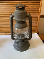 Front side view of antique Beacon railroad lantern showing embossed logo and glass globe