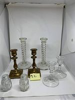 Photo showing all items: two brass candlesticks, two tall clear glass candlesticks, two short clear glass candlesticks, and salt and pepper shakers.