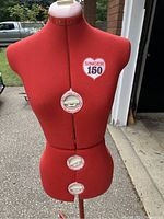 Front view of red Singer 150 form showing three adjustment dials at bust, waist and hip