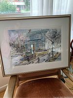 Framed watercolor print showing a house on Main Street in Kleinburg, the frame has a white double mat and a gold accented frame, approximately 28x22 inches in size.