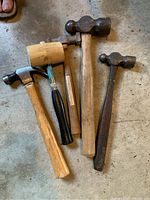Top view of five mallets showing type and size variety, including rubber-headed and metal-headed mallets with wooden handles.