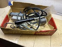 Photo of soldering iron, power transformer, solder coil, and metal stand in original box with visible branding and text.