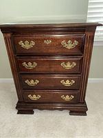 Front view of one bedside chest showing three drawers with brass pulls and fluted side panel detail.