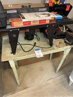 Sears Craftsman router table on worn wooden table with power cord visible, a note nearby.