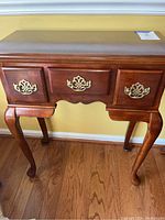 Front view of the Queen Anne style side table showing three drawers and cabriole legs.