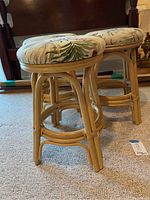 Photo of two rattan bar stools showing side profile, highlighting the curved rattan frame and height of the stools.