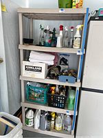 Full view of Sterilite 5 shelf plastic storage unit with multiple items on shelves, showing overall size and condition.