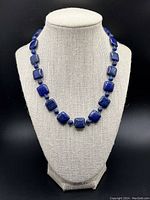 Front view of the deep blue Lapis Lazuli necklace displayed on a beige fabric bust.