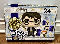 Box of Harry Potter Funko Pop Advent Calendar featuring Harry Potter on the front, showing original packaging with holiday theme and window for figures.