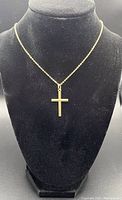 Gold cross pendant displayed on black mannequin showing full chain length and pendant size.
