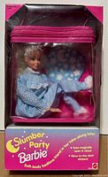Front view of sealed box showing Barbie doll in pajamas inside a clear zippered tote bag.