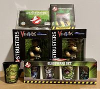 Full view of all lot items including shot glass set, Slimer shot glass, wallet, screen cleaner, and two boxed Ray Vinimates figures