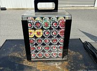Two poker chip sets displayed inside rectangular transparent plastic cases with black handles, showing colorful poker chips organized inside.