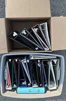 Top-down view showing the binders arranged in two containers, highlighting various colors and sizes.