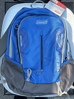 Front view of the blue Coleman Elate 35L backpack showing main zip, front zip pocket, mesh side pockets, and logo.