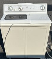 Full front view of the white Hitachi portable washer dryer combo unit showing the dual compartment top lid and power cord.