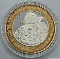 Obverse of the token showing relief portrait of man with cowboy hat and fur coat, outer gold ring with "Limited Edition Ten Dollar Gaming Token Horseshoe" inscription.