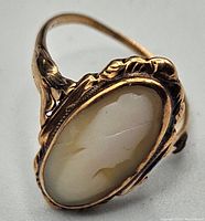 Close-up of the antique cameo ring showing the detail of the hard stone cameo and decorated 10K gold frame with visible stress crack.
