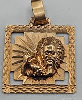 Front view of square 10k gold pendant with sunburst design and relief bearded face