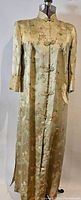 Full length front view of the vintage brocade silk satin robe on mannequin showing floral and cloud brocade pattern in pale greenish-gold fabric.