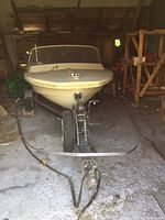 Front view of boat on trailer inside barn